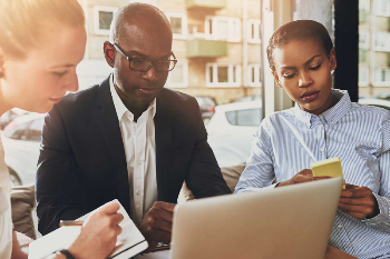 Business people looking onto a computer together