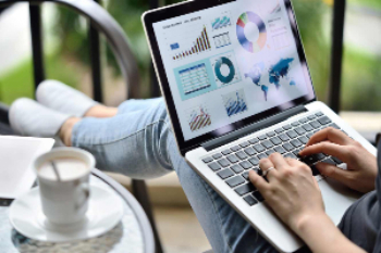 Woman sitting in a chair looking at charts on her computer